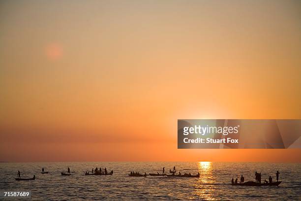 local zambian fishermen in 'plank' boats at sunset - tanganyikasjön bildbanksfoton och bilder