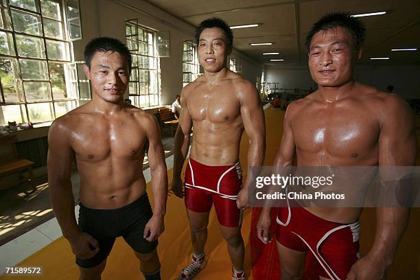 Athletes of Inner Mongolia Wrestling Team display their muscle during training at a training center on August 4, 2006 in Hohhot of Inner Mongolia...