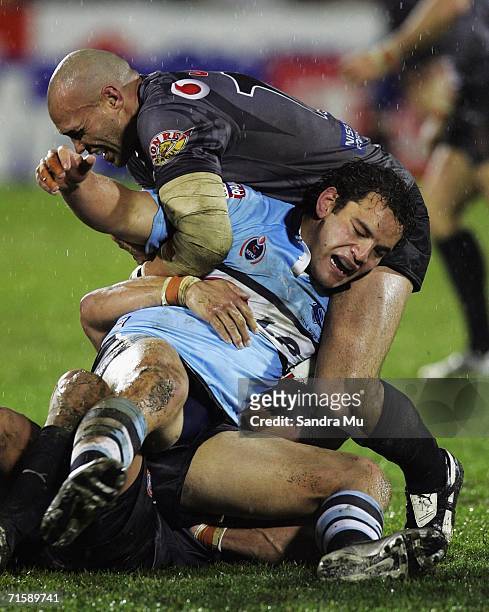 Awen Guttenbeil of the Warriors tackles Richard Villasanti of the Sharks to the ground during the round 22 NRL match between the Warriors and the...
