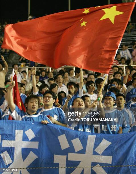 Chinese supporters cheer as they wave a national flag before the A3 Champions Cup 2006 match between China's Dalian Shide FC and Japan's JEF United...