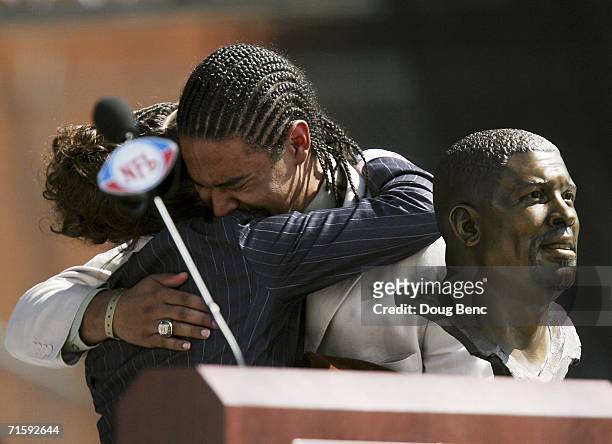 Sara White, wife of the late defensive end Reggie White, and his son Jeremy White, react after the unveiling of Reggie White's bust during the Class...