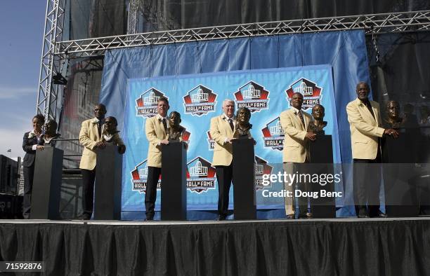 Sara White, wife of the late Reggie White, Harry Carson, Troy Aikman, John Madden, Warren Moon and Rayfield Wright pose with their busts' after their...