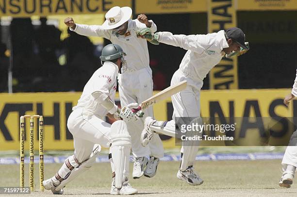 Mahela Jayawardene and Prasanna Jayawardene of Sri Lanka celebrate the wicket of South African cricketer Nicky Boje during the fourth day of the 2nd...