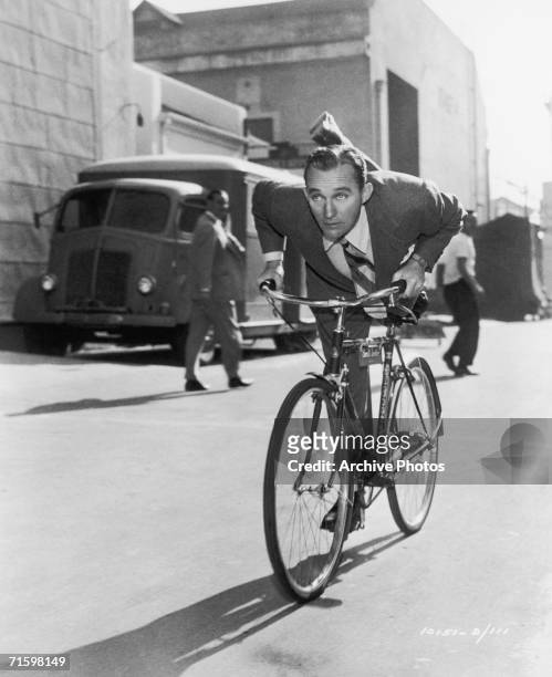 American actor and singer Bing Crosby demonstrates some fancy footwork whilst crossing the Paramount studio lot on his way to work on whimsical Irish...