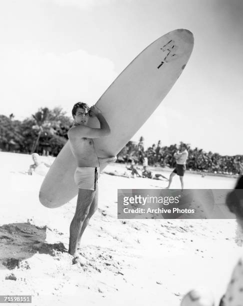 American teen idol and pop star Fabian Forte poses with a surboard, circa 1960.