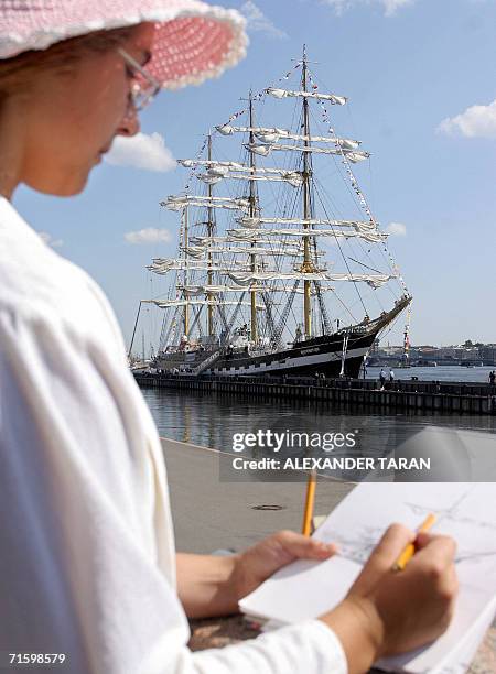 Woman draws the "Kruzenshtern" sailing ship at a berth in St.Petersburg, 07 August 2006. "Kruzenshtern" is the world's second largest sailing ship...