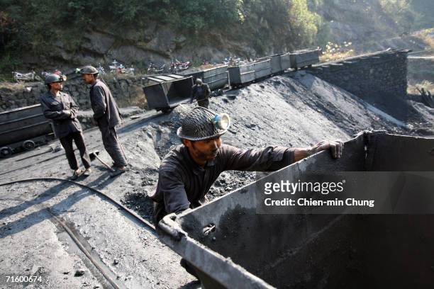 Coal miner after dumping a container of coal outside a mine December 6, 2005 outside of Fengjie, Sichuan province.