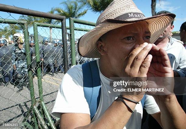 Tegucigalpa, HONDURAS: Maestros hondurenos protestan frente a una valla metalica de seguridad instalada por la Policia Nacional en el bulevar Juan...