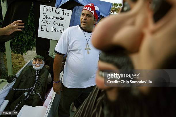 In a macabre display, a rubber mask of Osama Bin Laden look on as Cuban immigrant Jorge-Luis Quiroga prepares a likeness of Fidel Castro in a casket...