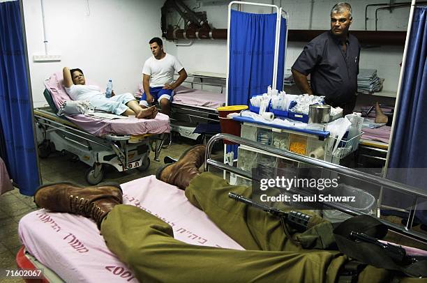 Wounded Israel soldier lies in his bed with his gun in an emergency room on August 7, 2006 in Nahariya, Israel. In the past few weeks the Nahariya...