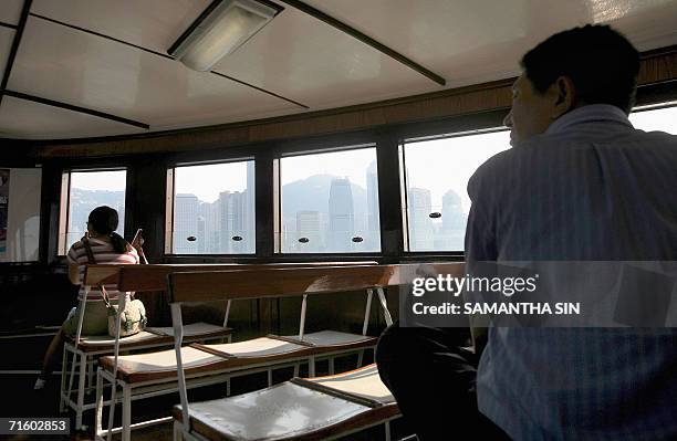 Passengers view the skyline of Hong Kong, 08 August 2006, from inside one of the many ferries that cross the harbour daily. Pollution has become such...