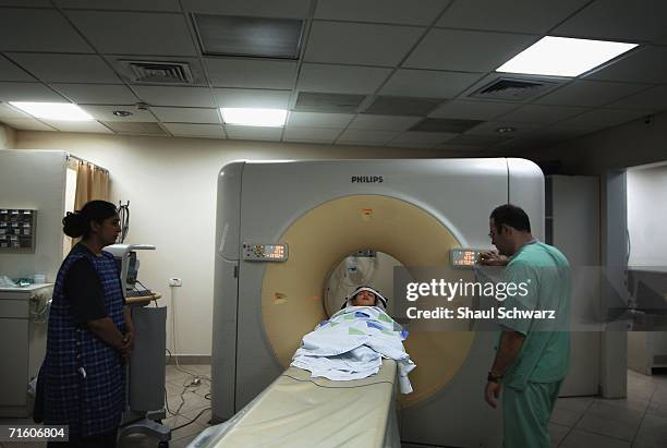 Woman looks at her child during a CT scan in the Nahariya hospital after he suffered a concussion while trying to run for shelter during a missile...