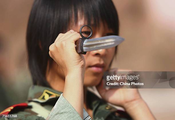 Member of a female grappling team from Qinghai Province armed police undergoes dagger exercise on August 8, 2006 in Xining of Qinghai Province,...