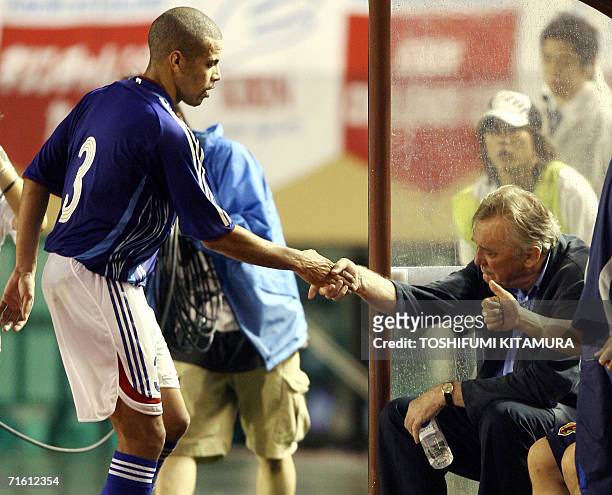 Japan's head coach Ivica Osim from Bosnia congratulates defender Alex Santos who was substituted in the second half of the friendly match against...