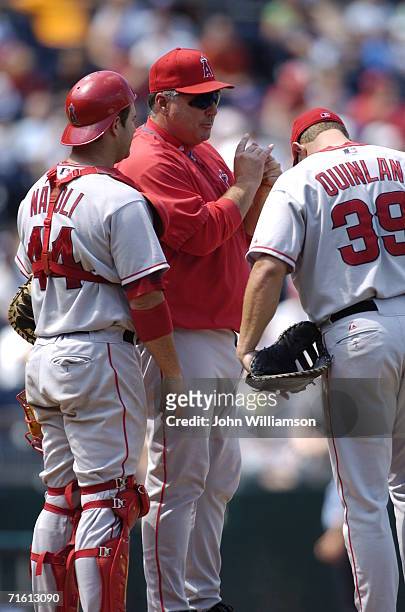 Manager Mike Scioscia of the Los Angeles Angels of Anaheim talks to catcher Mike Napoli and first baseman Robb Quinlan as he waits for a relief...