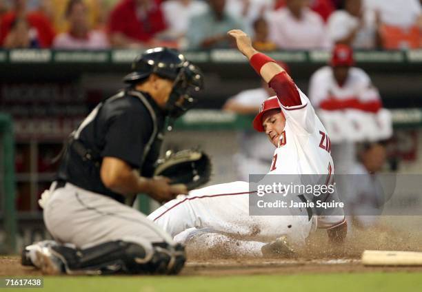 Ryan Zimmerman of the Washington Nationals slides safely into home to score on a Alex Escobar sacrifice to right field for the Nationals third run...