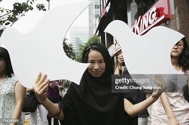 South Korean activist holds up white dove symbols as she protests Israeli attacks in Lebanon in front of the Israeli Embassy August 10 South Korea....