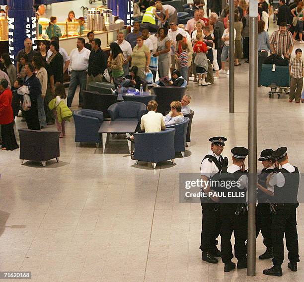 Manchester, UNITED KINGDOM: Police men are seen near queues of passengers at Manchester Airport, 10 August 2006 in Manchester, northern England....