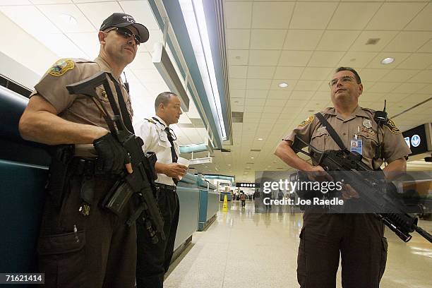 Miami-Dade police officers Eddie Garcia and Carlos Quintana, carry their weapons as they patrol the Miami International Airport August 10, 2006 in...