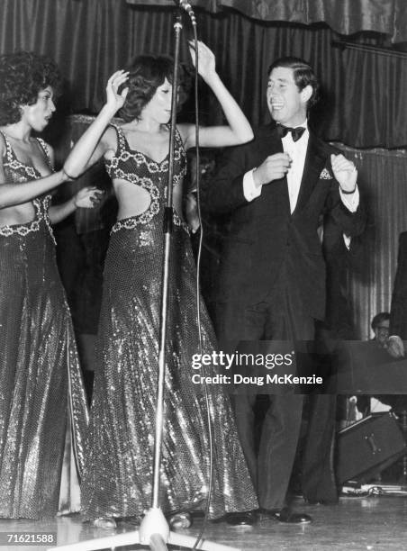 Prince Charles takes the stage with American vocal soul group the Three Degrees during a charity fundraiser for the Prince's Trust at the King's...