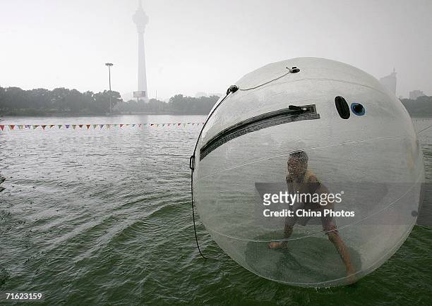 Boy plays in a water walking ball at Yuyuantan Park on August 10, 2006 in Beijing, China. The ball, that is 2.5 meters in diameter and filled with...