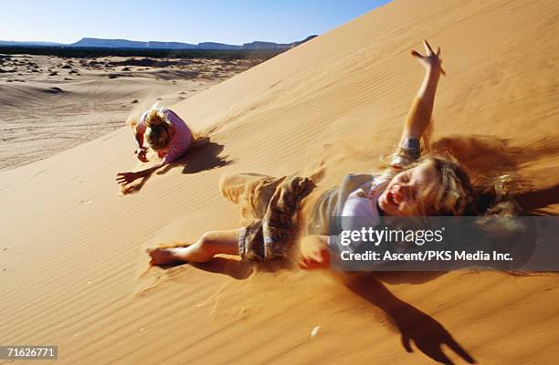 mother and daughter rolling down sand dunes, coral pink sand dunes state park, united states of america - de rola imagens e fotografias de stock