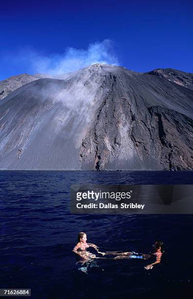 swimming below lava covered scarra del fuoco (trail of fire), ficogrande, italy - stromboli stock-fotos und bilder