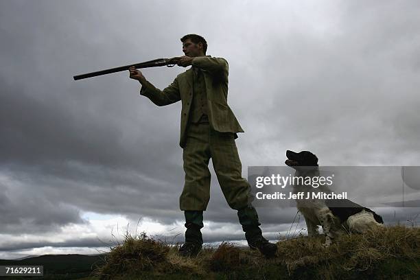 Amekeeper Andrew Drummond stands with his springer spaniel on Drumochter Moore on the Milton Estate on August 11, 2006 Dalwhinnie in Scotland.The...