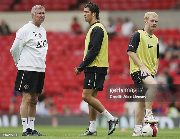 Sir Alex Ferguson the manager of Manchester United watches as Cristiano Ronaldo and Paul Scholes train during a Manchester United training session...