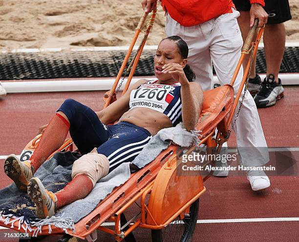 Jade Johnson of Great Britain is carried away from the pit on a stretcher as she sustains an injury during the Women's Long Jump Qualifying Round on...