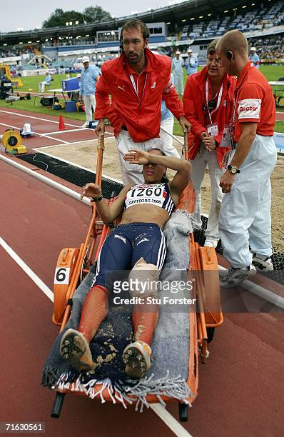 Jade Johnson of Great Britain is carried away from the pit on a stretcher as she sustains an injury during the Women's Long Jump Qualifying Round on...