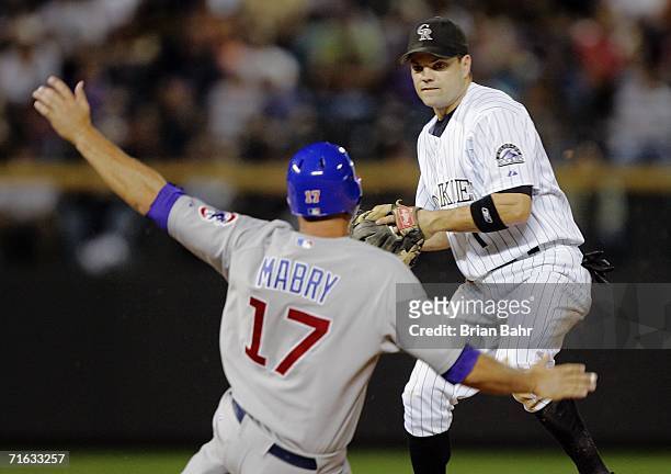 John Mabry of the Chicago Cubs breaks up a double play as second baseman Jamey Carroll of the Colorado Rockies considers a throw to first base...