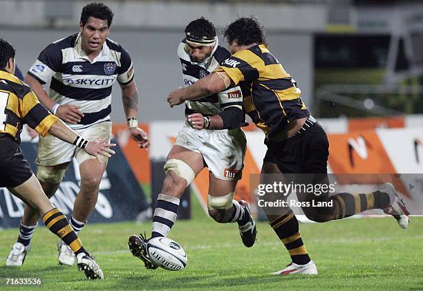 Andrew Blowers of Auckland chips the ball as he is tackled by Census Johnston of Taranaki during the Air New Zealand Cup match between Taranaki and...