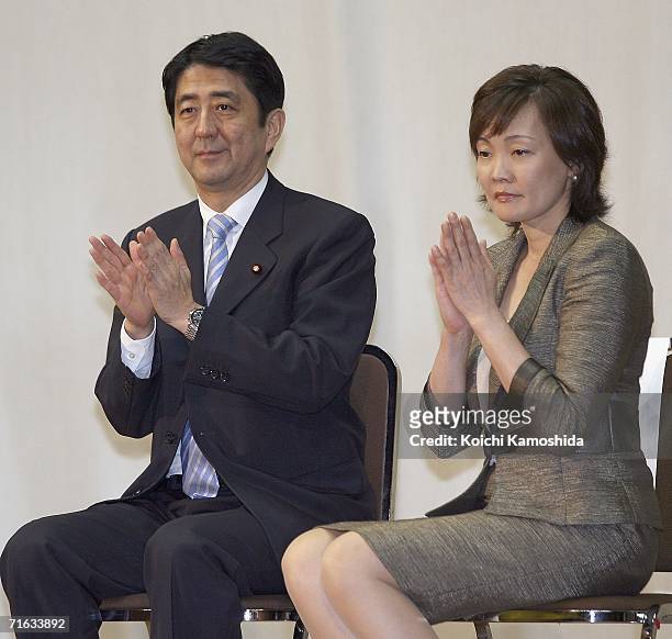 Japanese Chief Cabinet Secretary Shinzo Abe and his wife Akie Abe applaud during a press conference to announce his intention to stand as Prime...