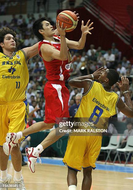 Chen Jianhua of China prepares to shoot as Anderson Franca Varejao and Leandro Mateus Barbosa of Brazil try to blocked during their Stankovic...