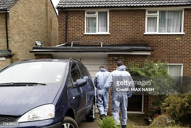 High Wycombe, UNITED KINGDOM: Two British police forensic experts go 13 August 2006 round the outside a house in High Wycombe, which was raided by...