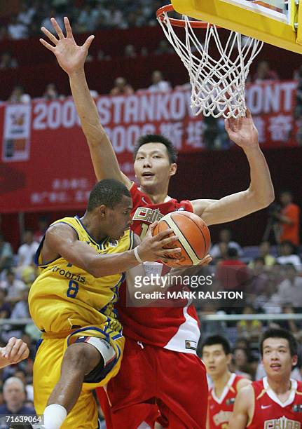 Yi Jianlian from China tries to block as Leandro Mateus Barbosa from Brazil prepares to shoot during their Stankovic Continental Champions Cup game...