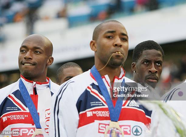 Team Great Britain members Marlon Devonish and Darren Campbell and Dwain Chambers stand with their gold medals during the medal presentation for the...
