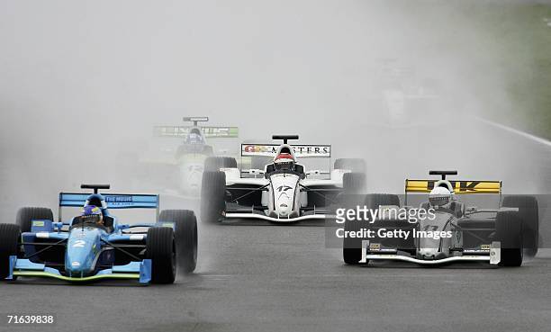 Eddie Cheever comes out of the mist following Stefan Johansson and Christian Danner during the GP Masters of Great Britain at Silverstone circuit on...