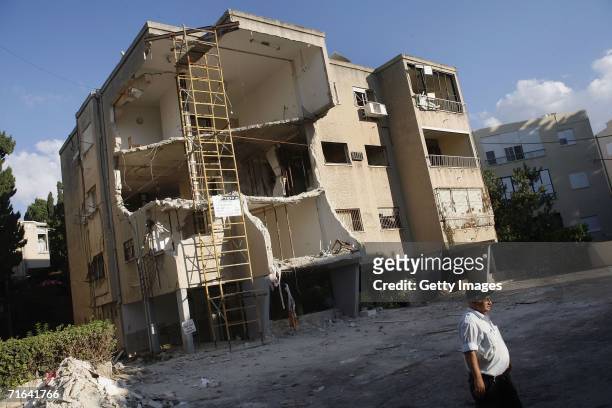 An Israeli security guard walks next to a building hit by a Katyusha rocket on July 17, wounding its habitants, August 14, 2006 in Haifa, Israel....