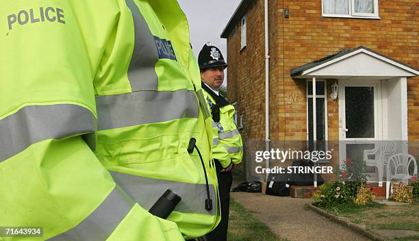 High Wycombe, UNITED KINGDOM: Police officers stand guard outside the house of one of the men arrested in anti-terror raids last Thursday morning in...