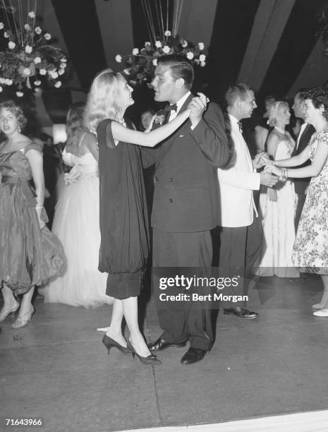 American musician Peter Duchin and Debra Dixon talk together and dance at the Andrews-Wanamaker Supper Dance, Southampton, New York, July 4, 1958.