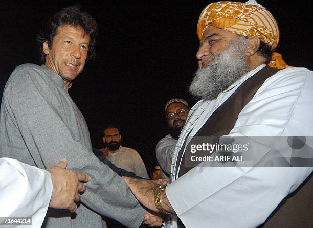 Pakistani opposition leaders Maulana Fazlur Rehman and Imran Khan shake hands prior to an anti-government procession on Pakistan's Independence Day...