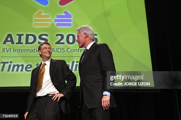 Bill Gates confers with former US president Bill Clinton at the end of the Symposium on "Priorities in Ending the Epidemic" at the XVI International...