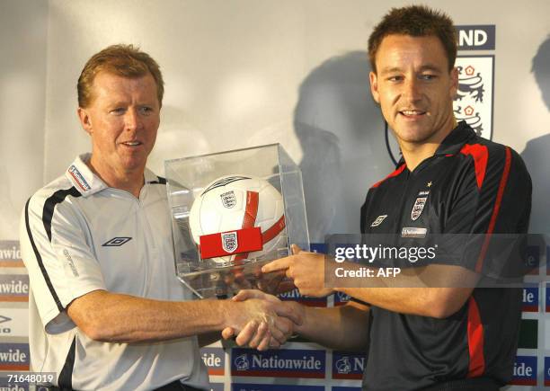 United Kingdom: England soccer captain John Terry recieves the captain's armband from manager Steve McClaren before a press conference at Old...