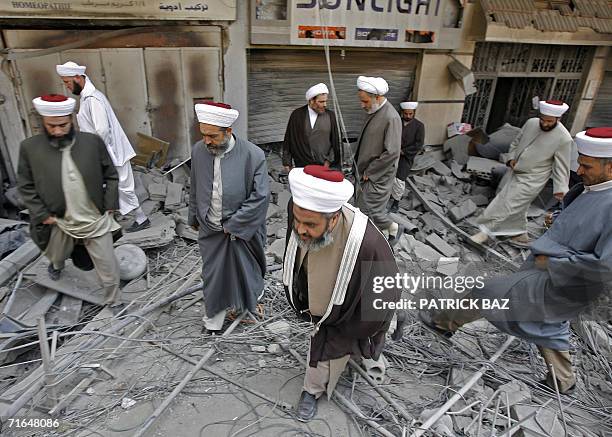 Lebanese Shiite and Sunni Muslim clerics make their way through the rubble as they visit, 15 August 2006, Hezbollah's "security perimeter" destroyed...