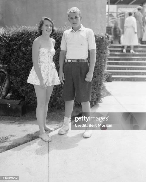 Future American fashion designer Mary McFadden stands with her stepbrother Harry van Gerbig at the entrance of the Southampton Bathing Corporation,...