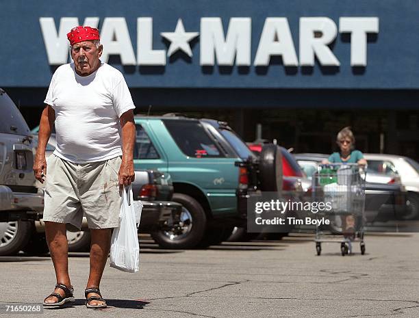 Two shoppers walk in the parking lot outside a Wal-Mart store August 15, 2006 in Mount Prospect, Illinois. Wal-Mart profits fell 26 percent for the...