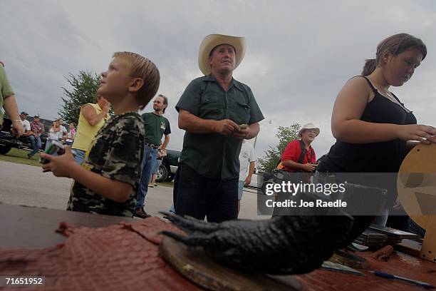 People wait for the raffle drawing to see who wins an alligator head or foot before hunters drop their airboats into Lake Okeechobee on the first day...