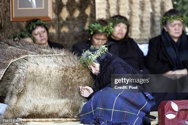 Mourners sit beside the body of the late Maori Queen, Dame Te Atairangikaahu, at the Turangawaeware Marae on August 16, 2006 in Ngaruawahia, New...